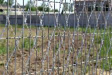 Сетка колюче-режущая Пиранья 2х6 на заборе из сварных панелей